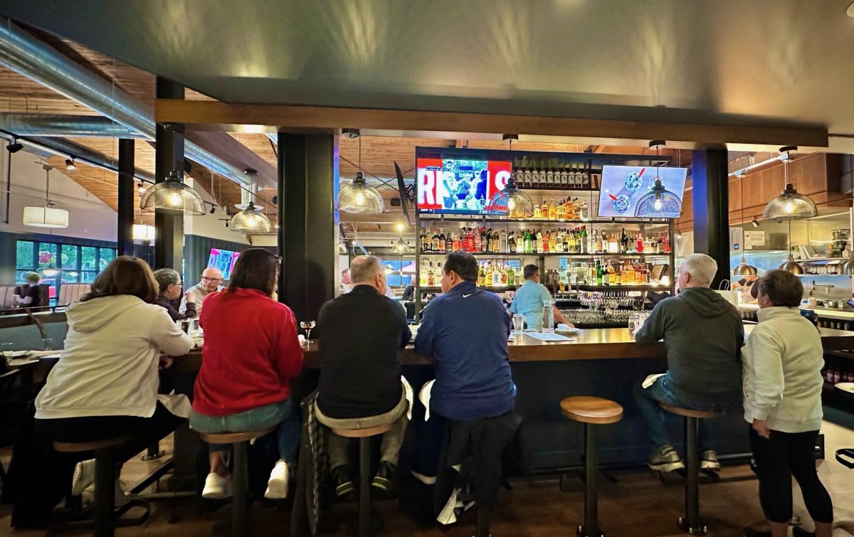 People sitting at the bar watching TV at The Victor Tavern in Edmonds, WA