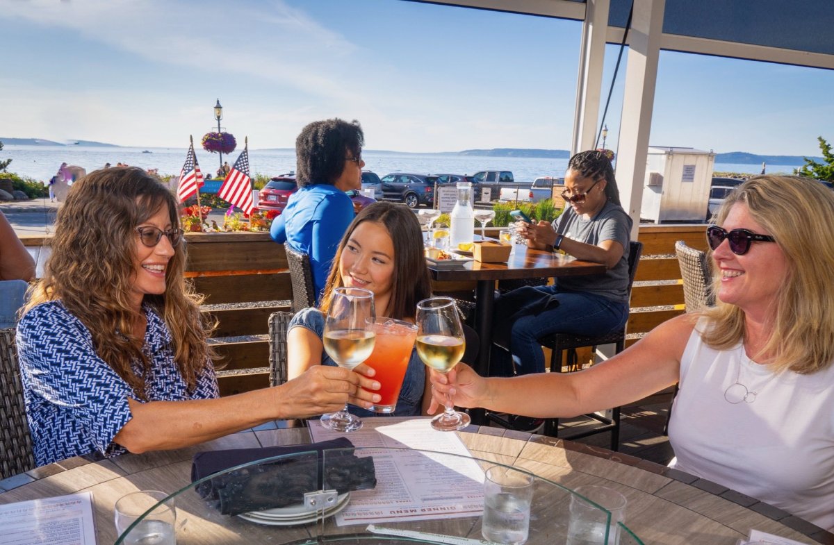 three women eating and drinking on the Demetri's deck in Edmonds